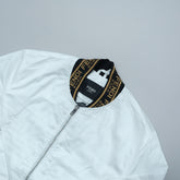White jacket with Fendi logo on a wooden surface